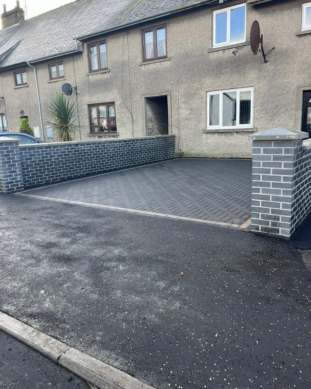 Charcoal monoblock driveway with brick pillars