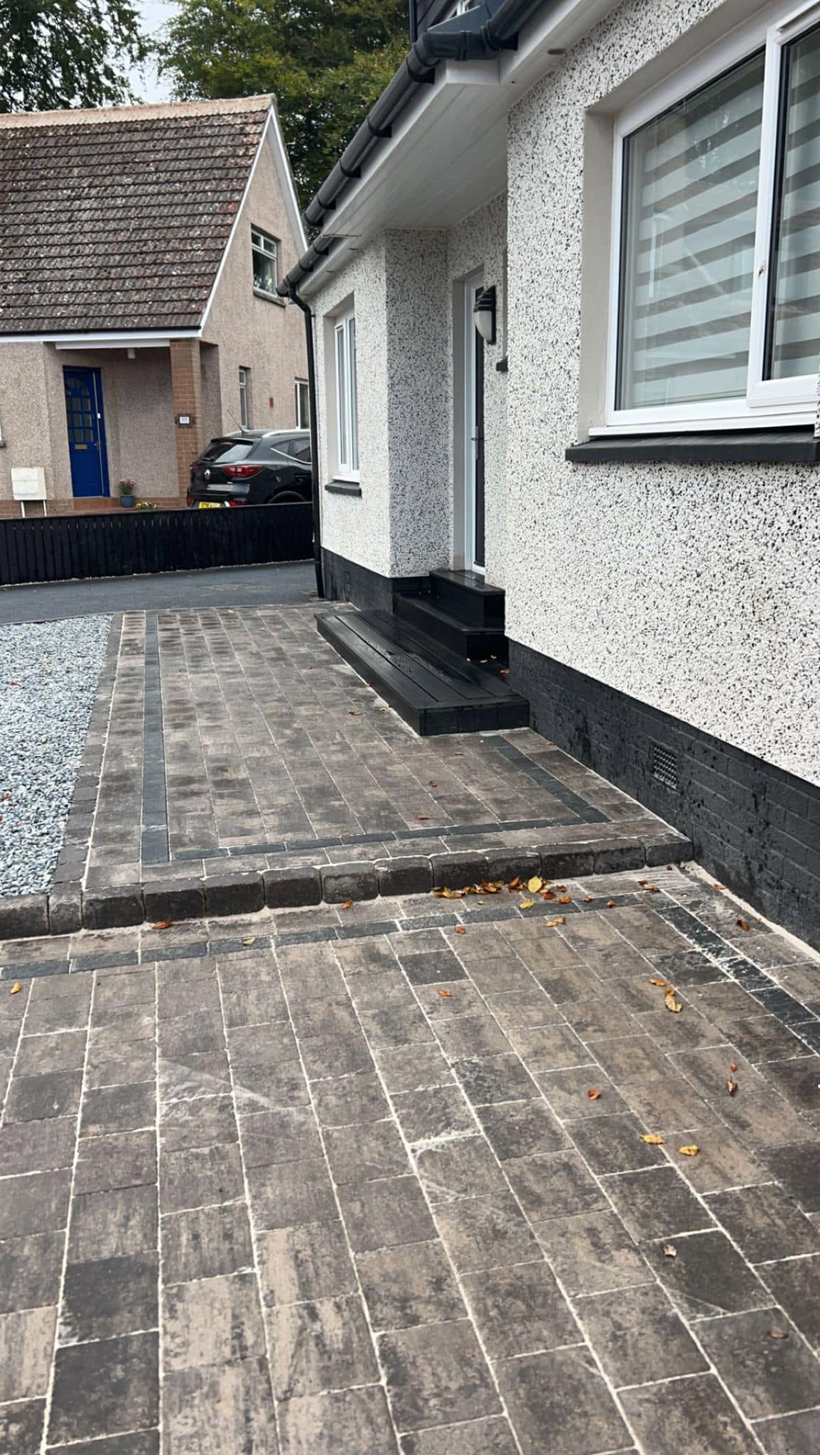 Block-paved path and steps beside a rendered house