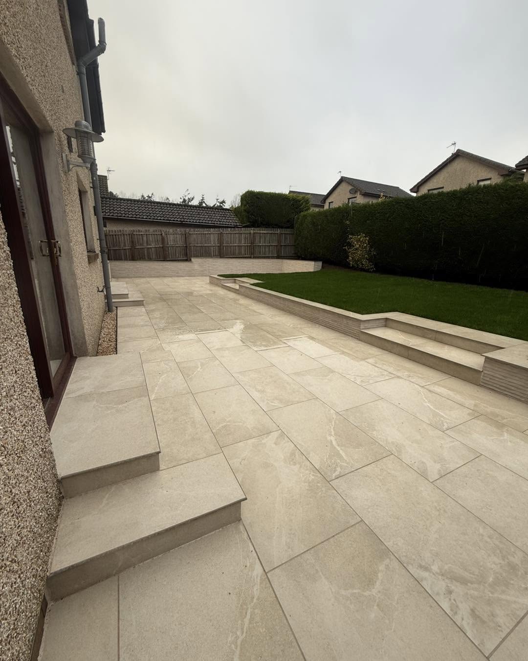 Indian sandstone patio with sleeper edging and artificial lawn